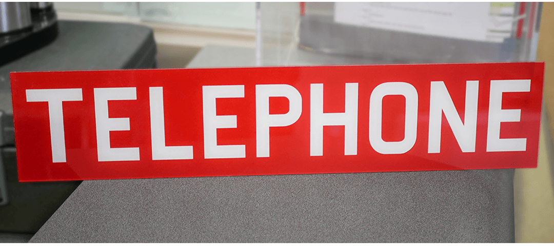 Printed acrylic sign with red background and white, capitalized lettering - TELEPHONE