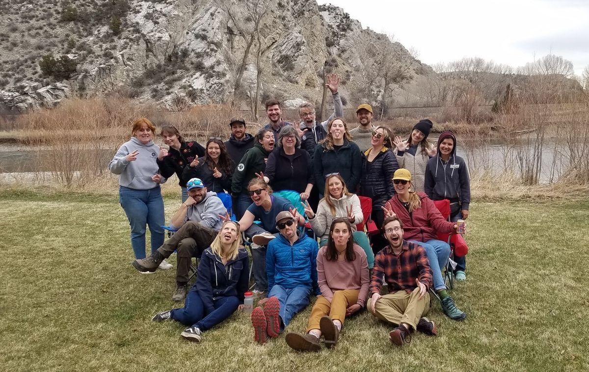 [Image Description: The staff from our Helena and Bozeman offices pose together in front of a river at a Spring Staff Picnic]