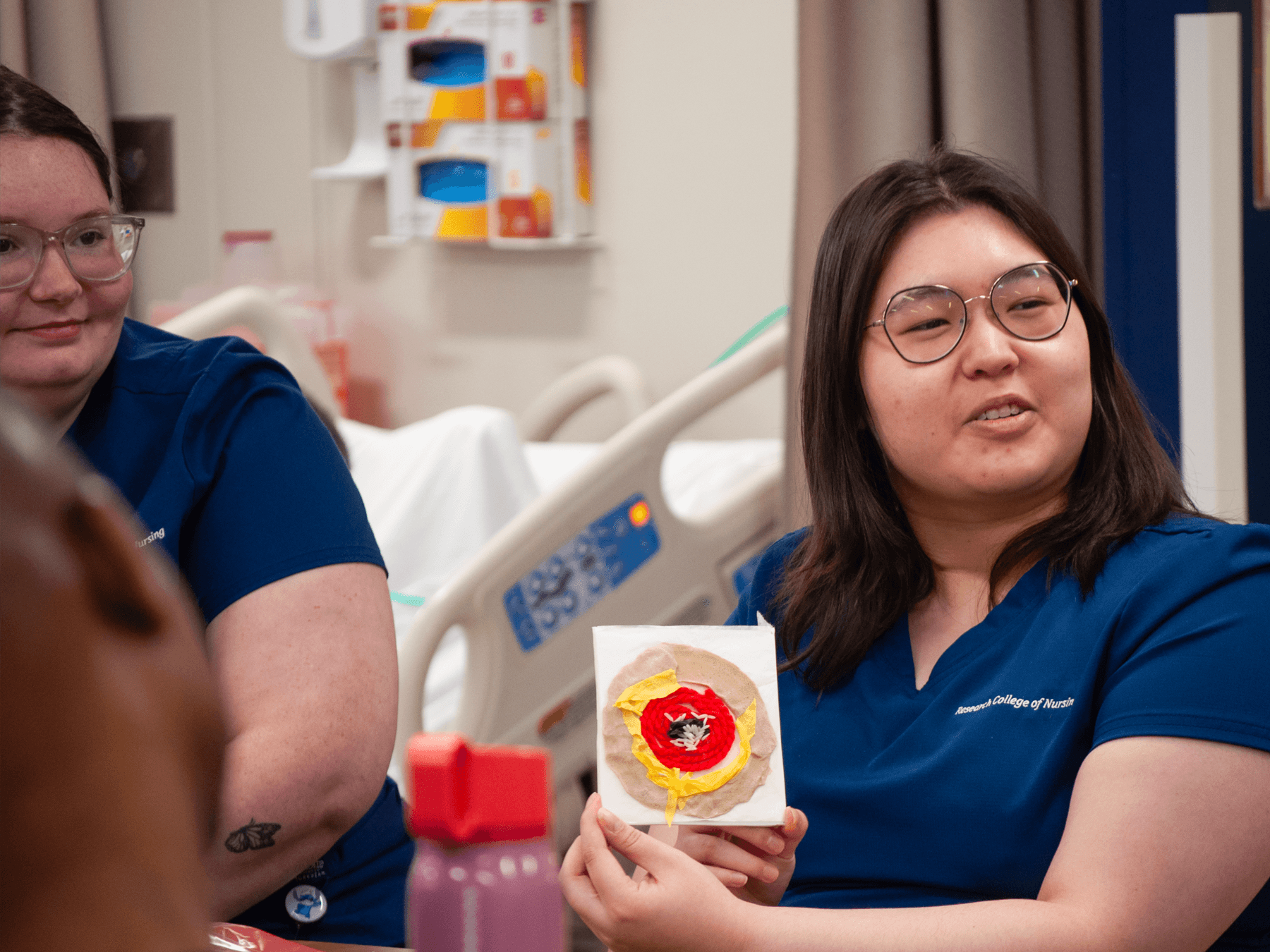 nursing student  holds up wound care demonstration