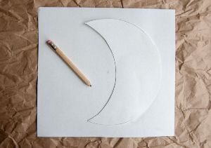 Crescent moon stencil on top of table runner fabric.