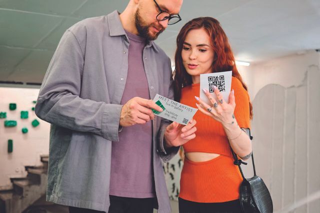 hipsters at art gallery looking at qr codes