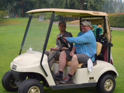 Executive Director Chad drives golf cart with SL Director Paul