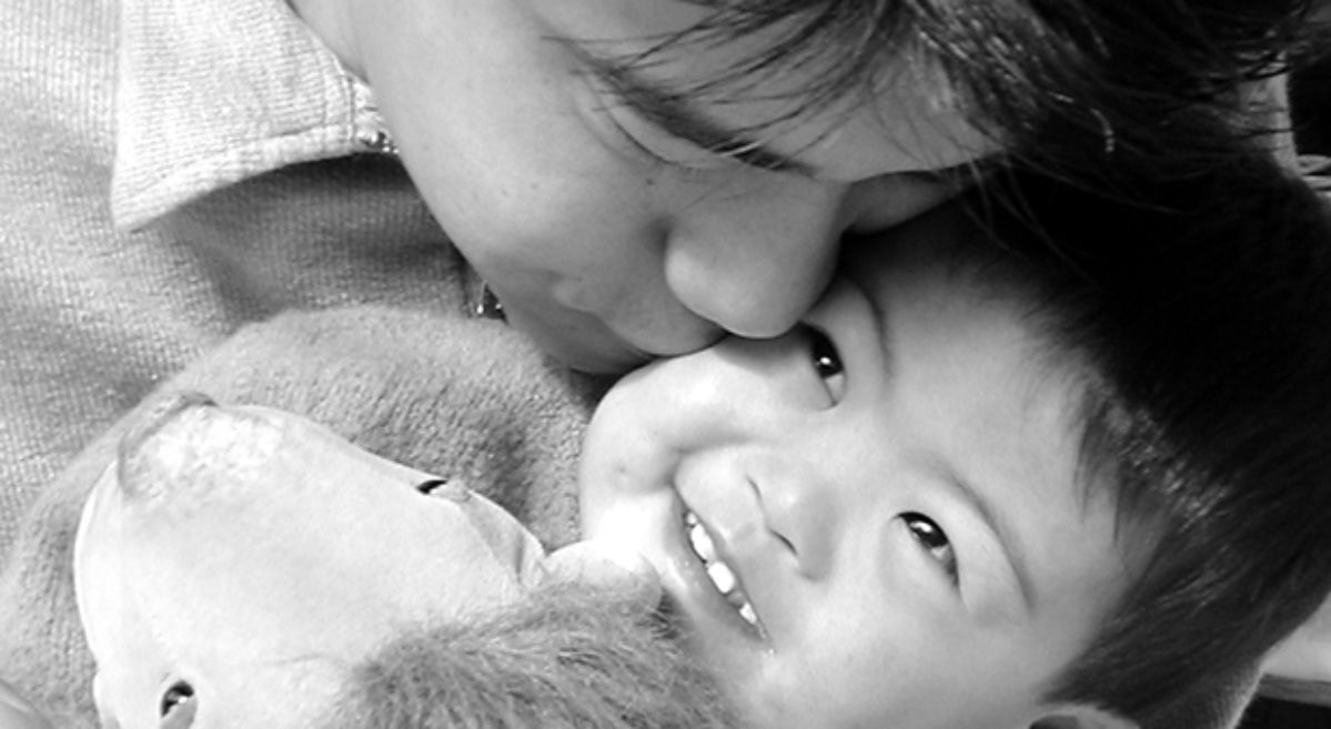 father kissing son with Down syndrome