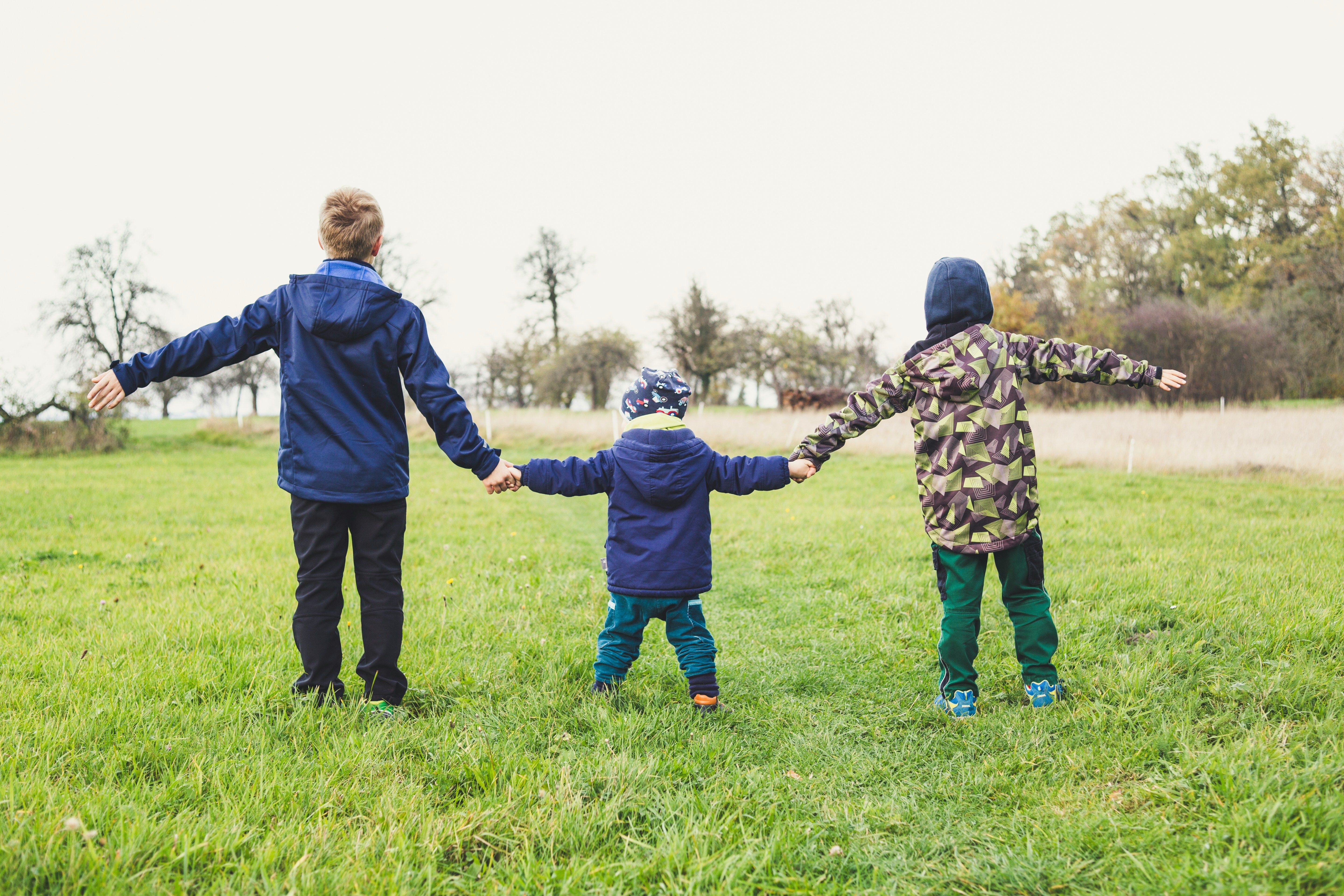 Three kids holding hands.