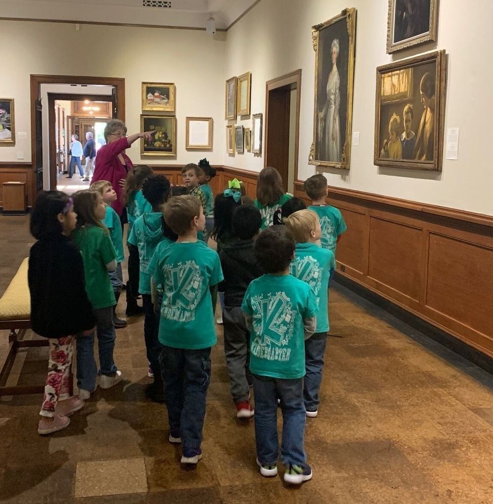 Museum docent talking to a group of students about a painting