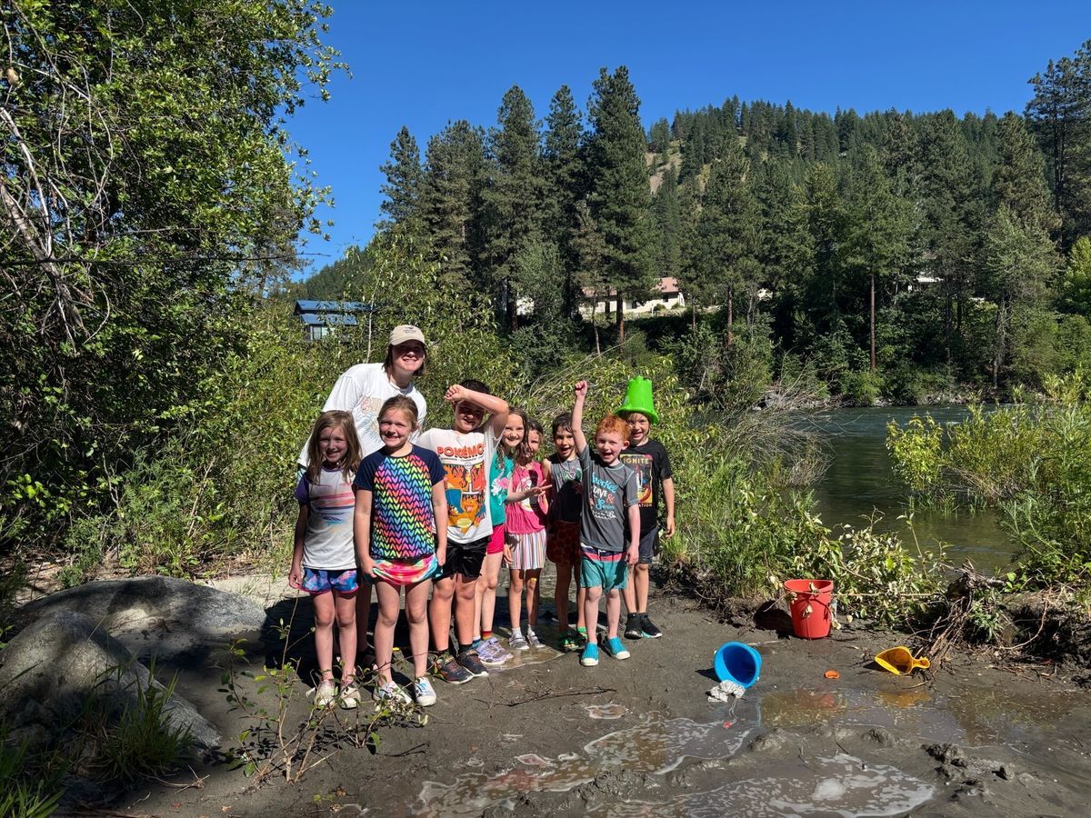 A photo of staff with students near the river in their swim gear during After School Program