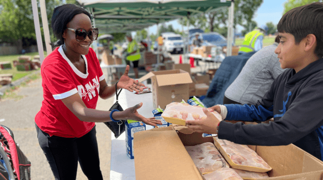Recipient receiving frozen chicken from a volunteer