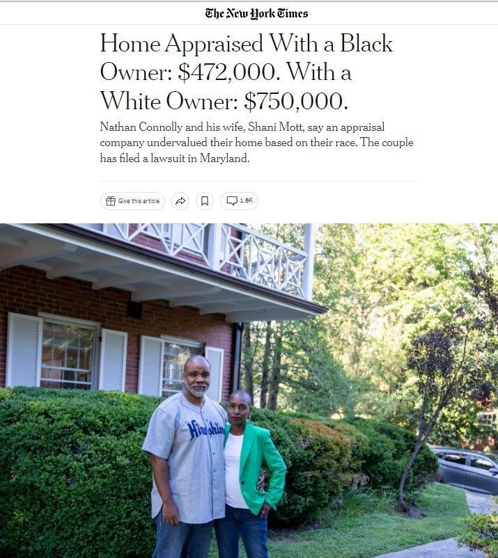 A Black man and a Black woman standing together in front of a house surrounded by trees and bushes. 