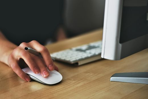 Person with hand on mouse with pen