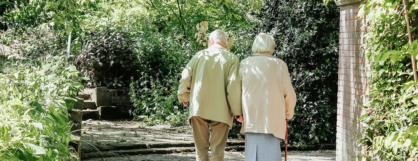 Elderly people walking and holding hands.