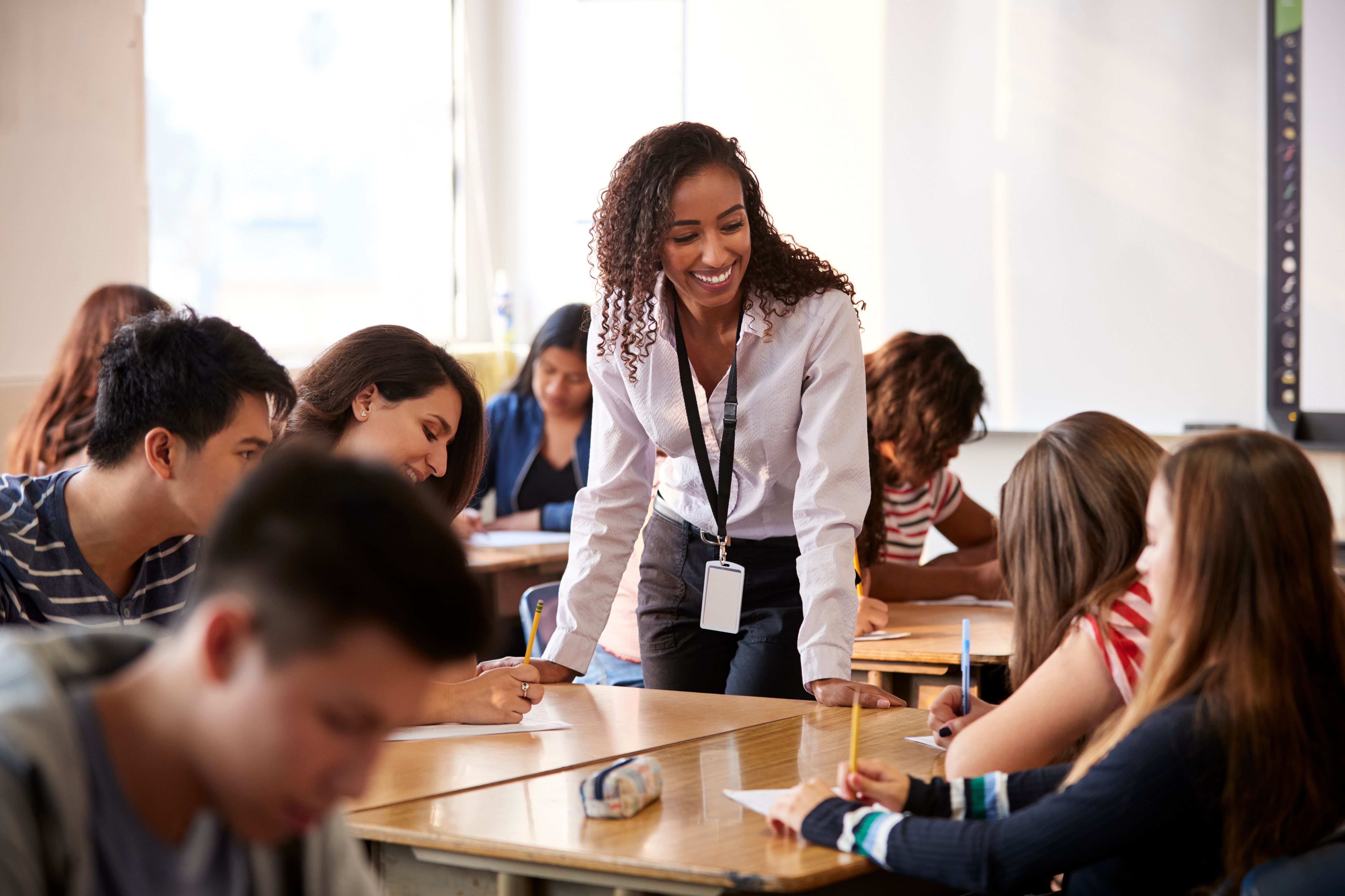 Smiling teacher with students at tables around her