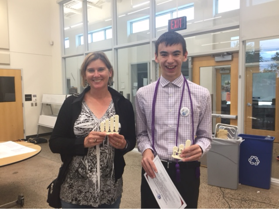 en Phillips and Austin holding 3D models of hair bundles and smiling.