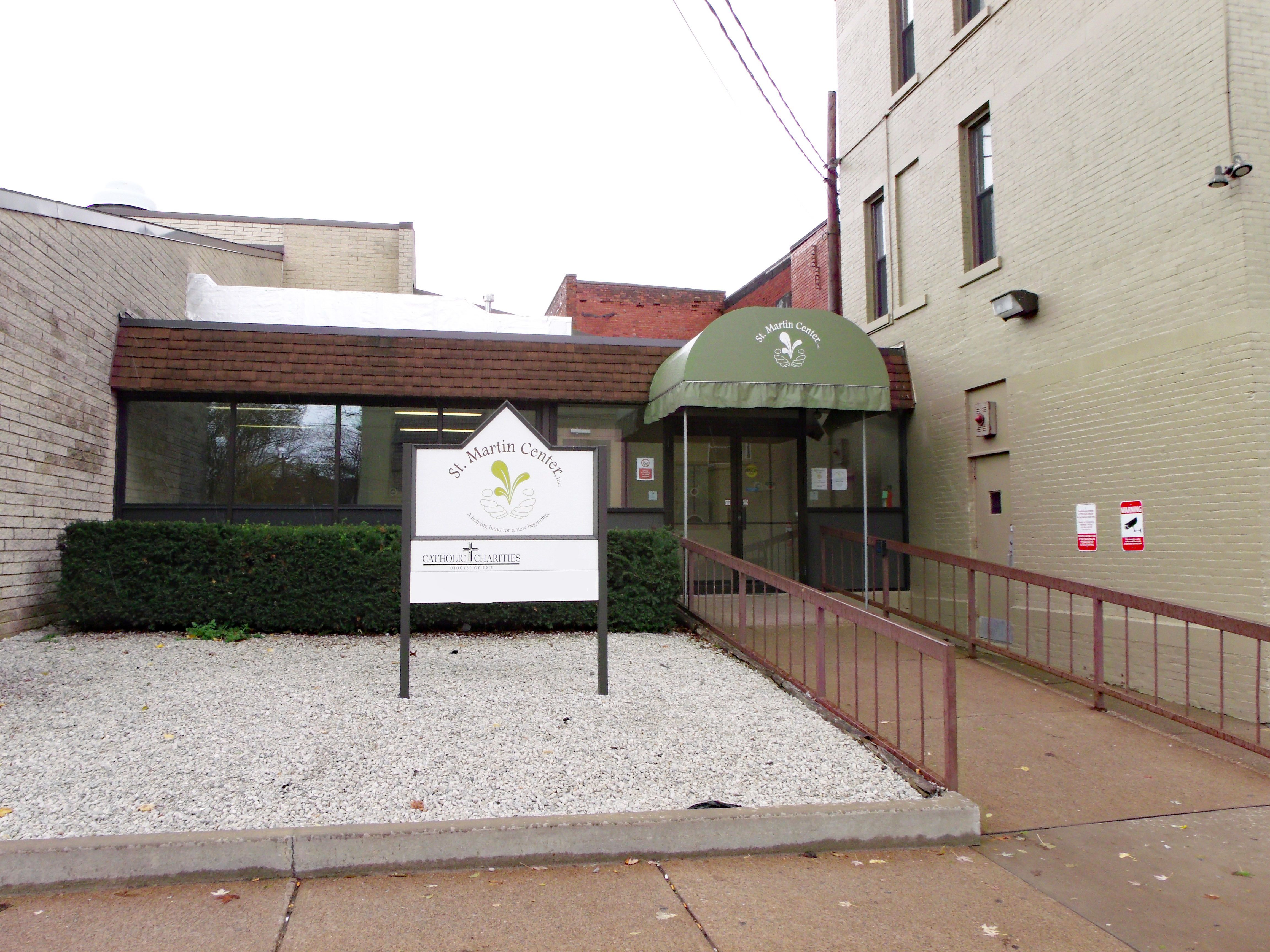 A view of the St. Martin Center building.  This faces a door with a ramp and an awning over top.  There is a sign that says "St. Martin Center"