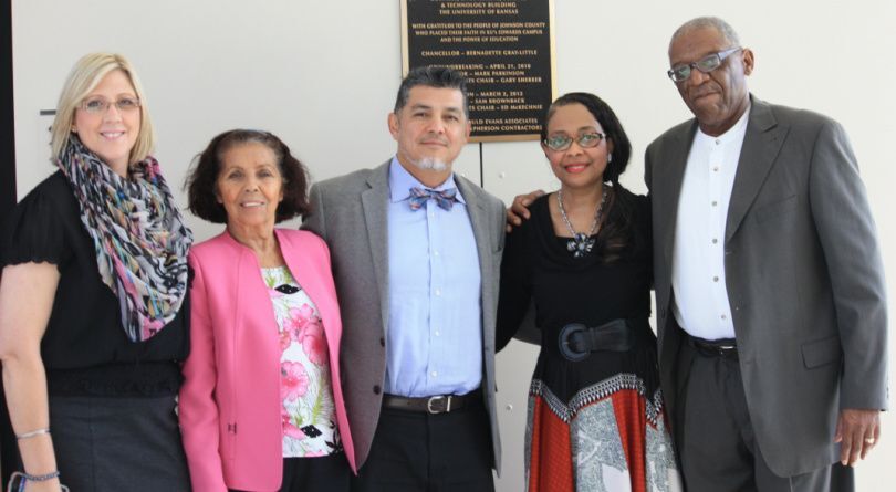 Five people standing togather and smiling at the camera. 
