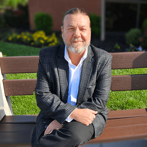 Man with beard sitting on a bench