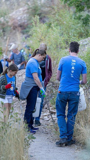 People picking up trash on a hike.