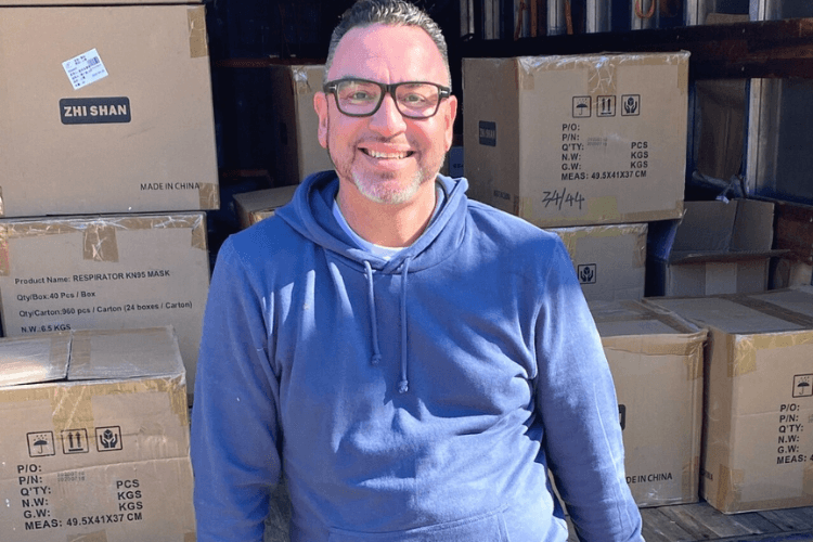 Man Smiling in front of Boxes
