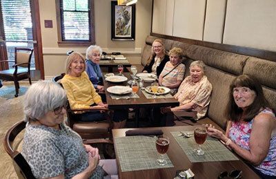 A group of seven people sitting around a dining table in a restaurant.