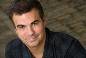 David Harrell. A man who is in his 30s, wearing a blue shirt and is posing for the picture.