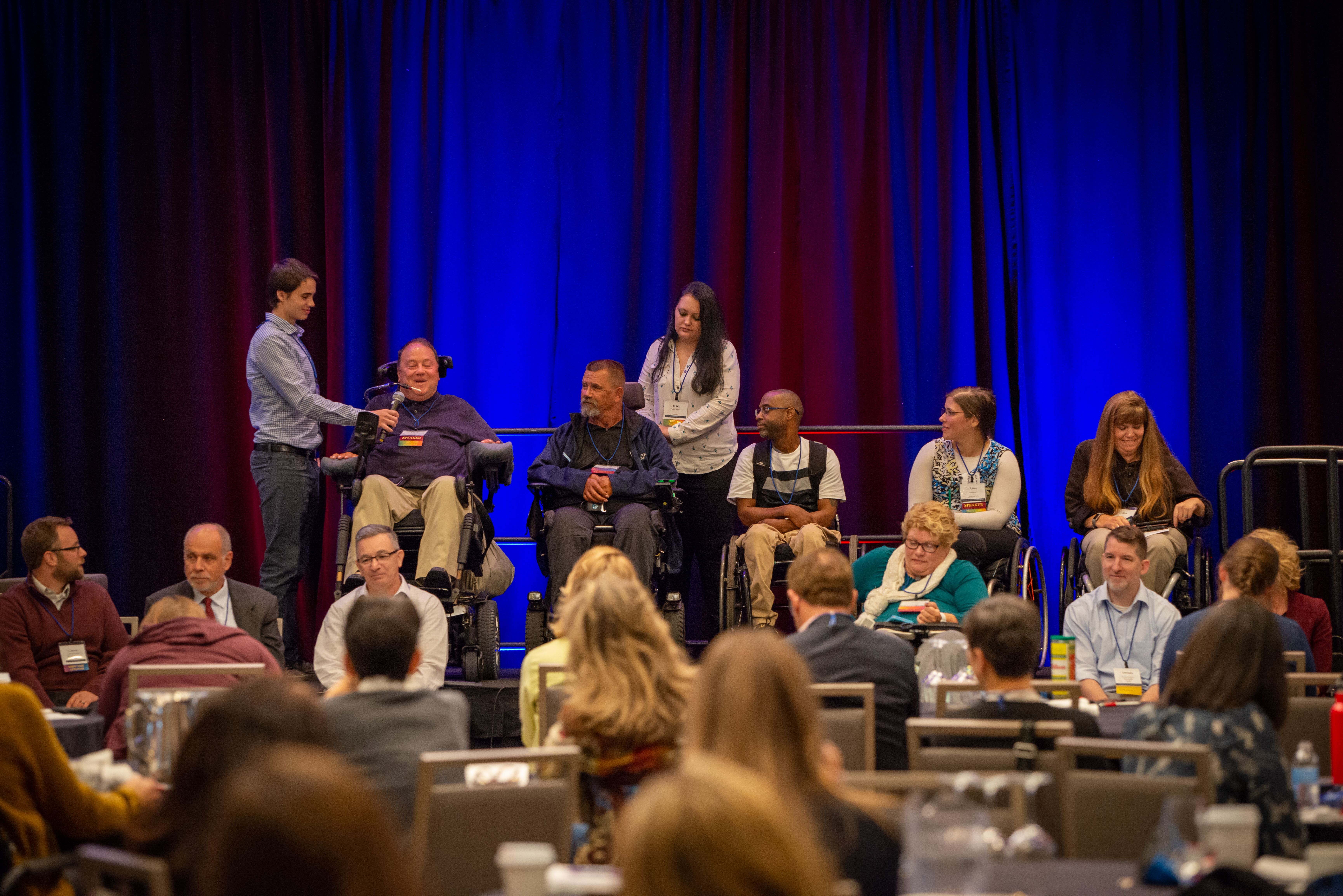 Group of men and women in wheelchairs on a stage