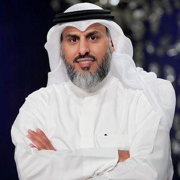 Bearded man wears a white headscarf (ghutra) with a black cord (egal), and a long, white dishdasha.