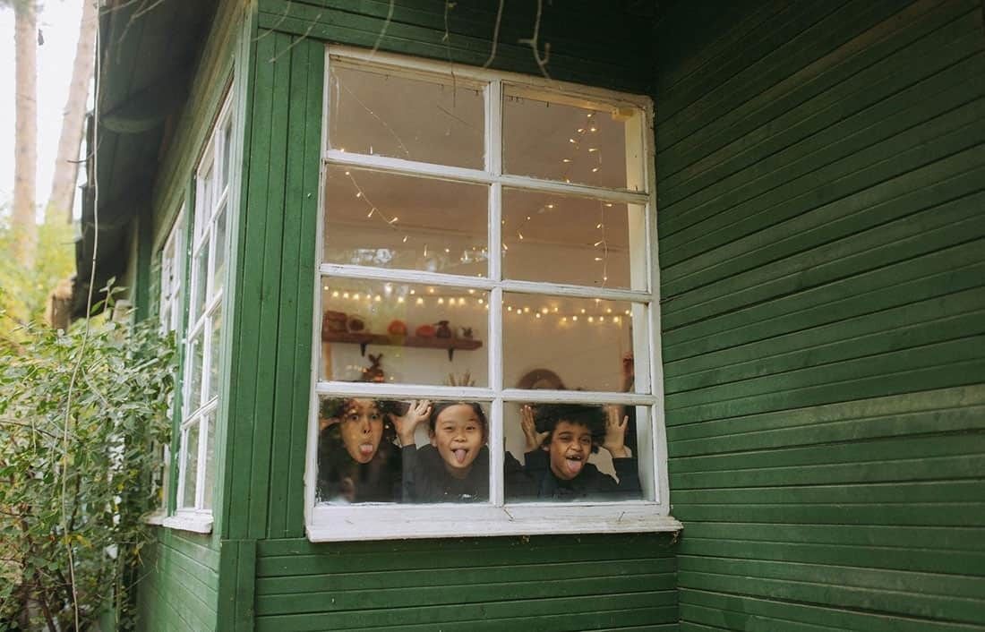 Children Making Faces Through Window