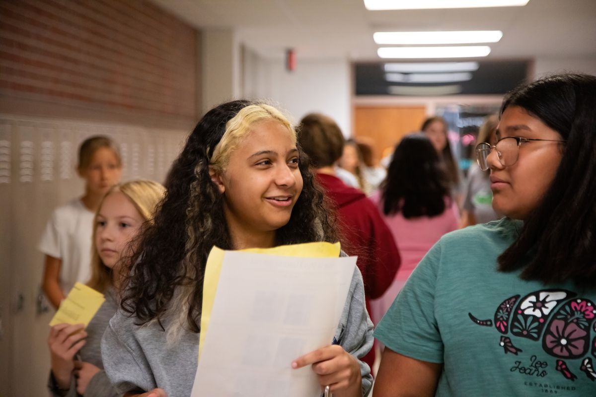 two students looking at each other in the hallway