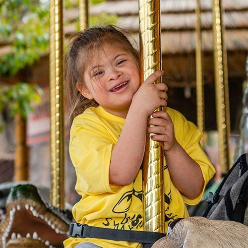 Smiling girl on carousel ride.