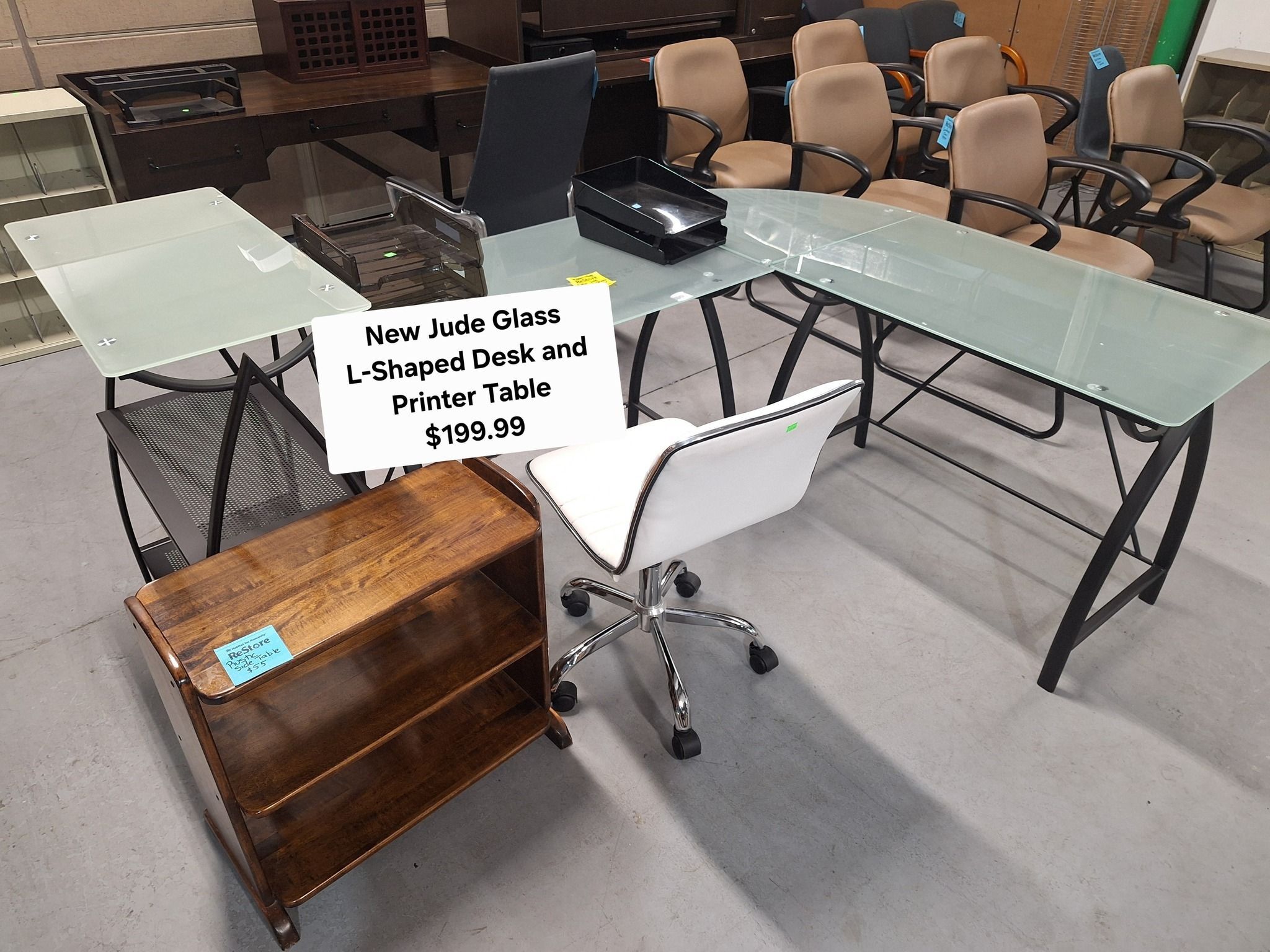 Modern Jude glass L-shaped desk with printer table, black metal frame, and white chair – perfect for home office – $199.99 at Habitat ReStore Zephyrhills