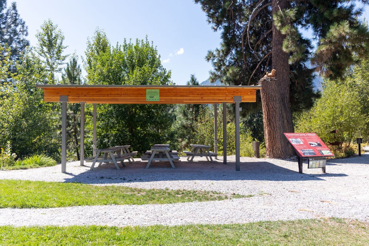 A photo of an outdoor covered structure with picnic tables.