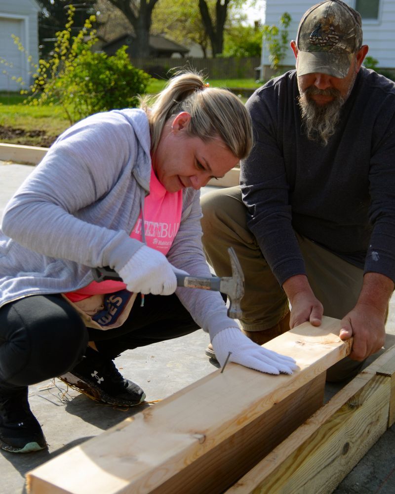 Future Habitat Homeowner, Kasandra nails drives the first nail into what will become her first house.