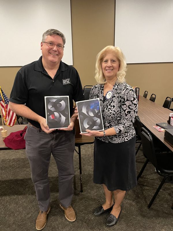 RISE Executive Director and CEO, Jeremy Bouman and a Bellevue Papillion Rotary Club member hold iPads donated to the RISE reentry organization.