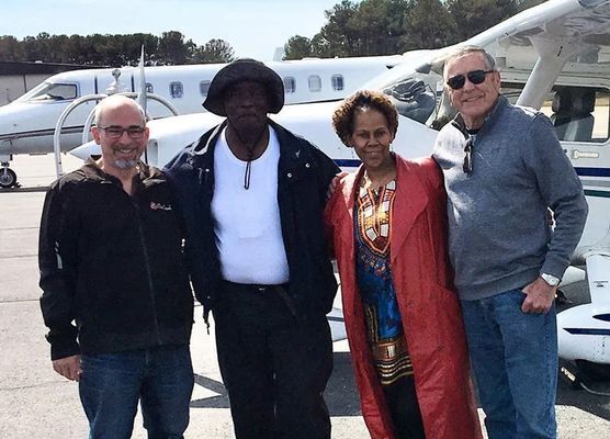 Group of people in front of a small plane.