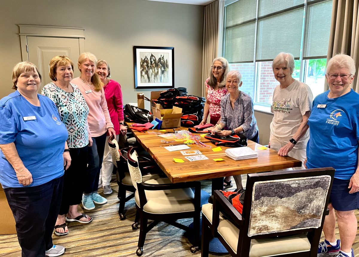A team of volunteers preparing sunshine and smiles kits at a retirement home