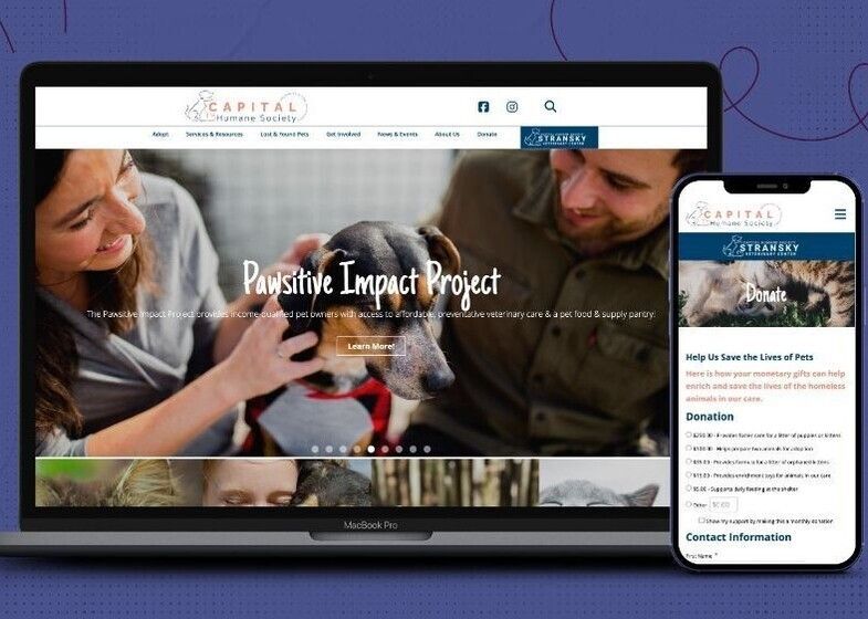 Image of a website's homepage on a laptop, side by side with the same homepage on a mobile device. Image on the home page is of puppy being pet by two adults. Text over the image reads Pawsitive Impact Project.