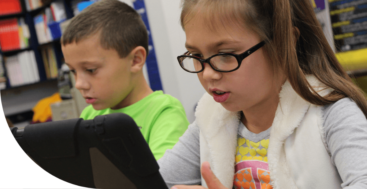 boy and girl students looking at a tablet