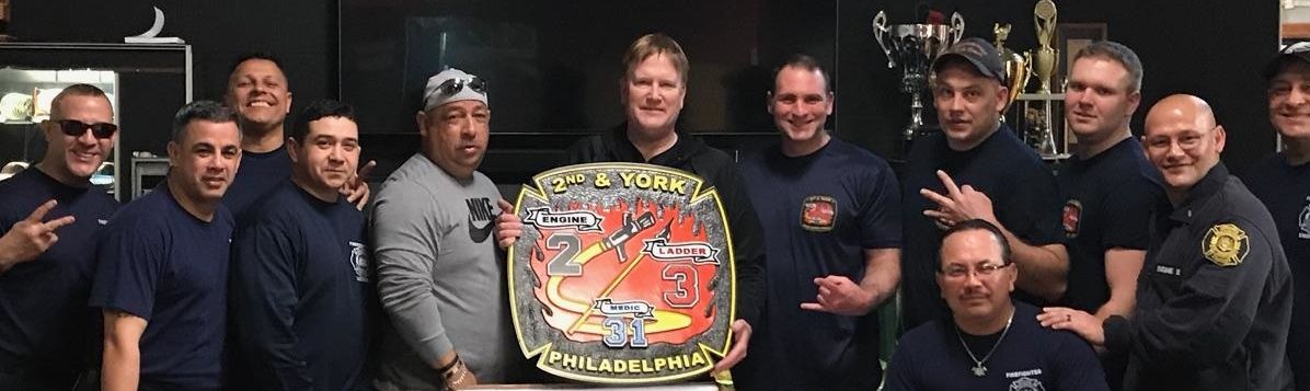 X33901 - Firefighters holding a  Plaque of the Logo  Shoulder Patch  of Engine 2, Ladder 3 of  the 2nd and York Station, Philadelphia Fire Department