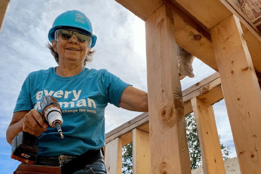Woman with drill helps build a house.