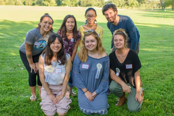Seven smiling interns of different races at outdoor event