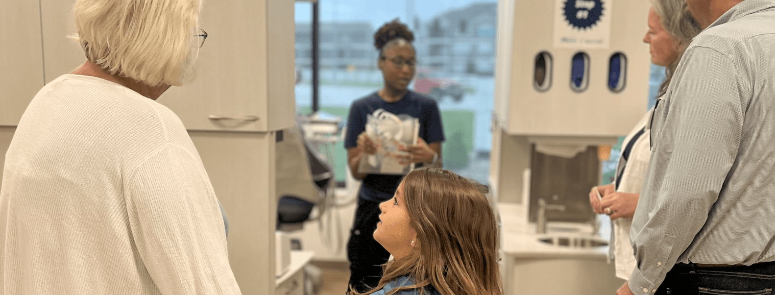 little girl looking at older woman in dental clinic