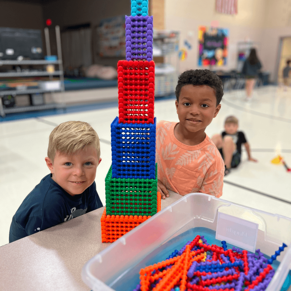 Two boys who attend Kids Club playing inside a gym