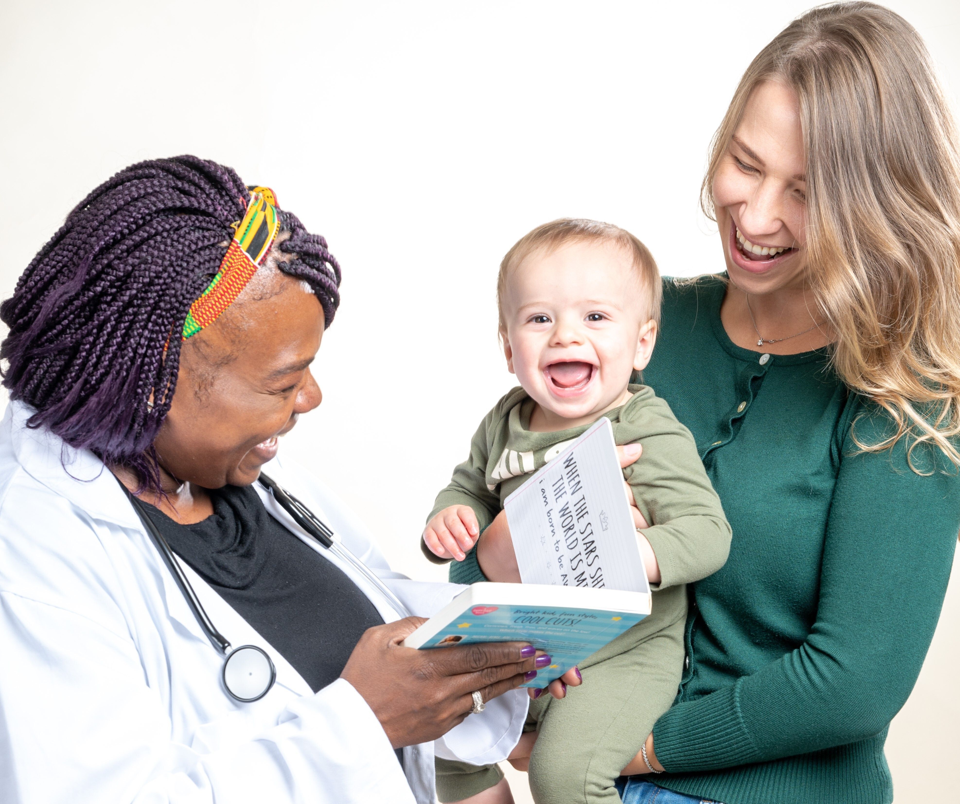 Doctor, mother, and toddler smile with a book together