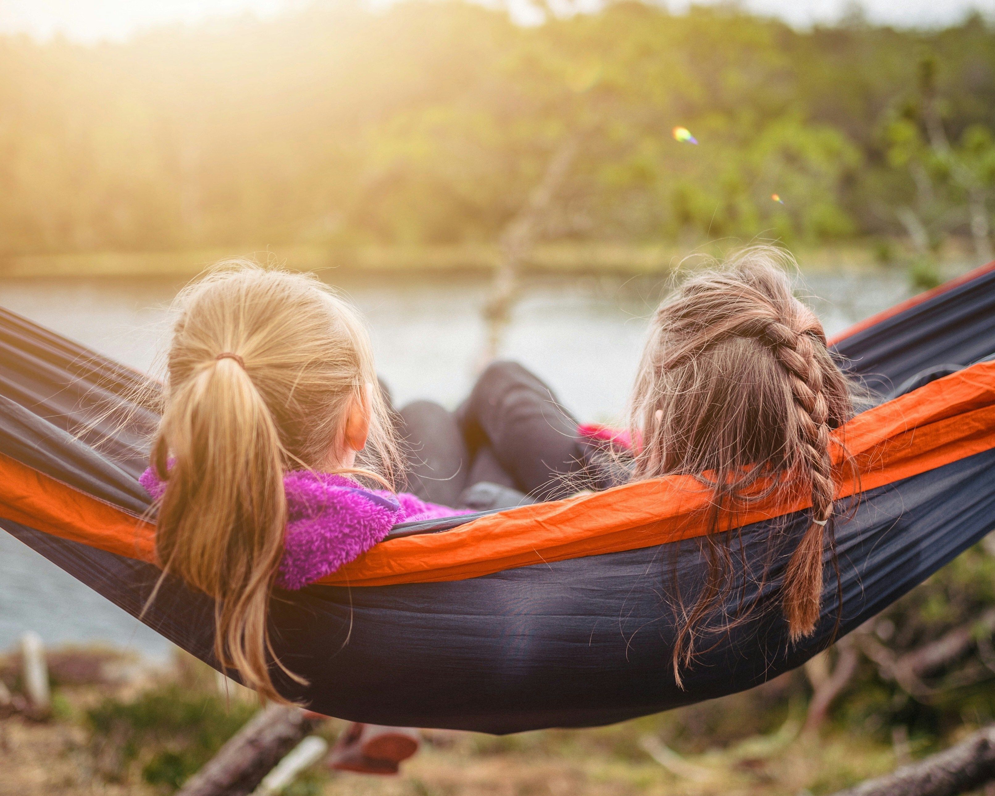 Two girls sitting in a hammock outside