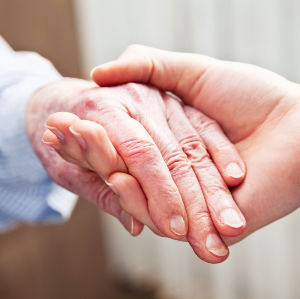 Young person's hand holding older person's hand