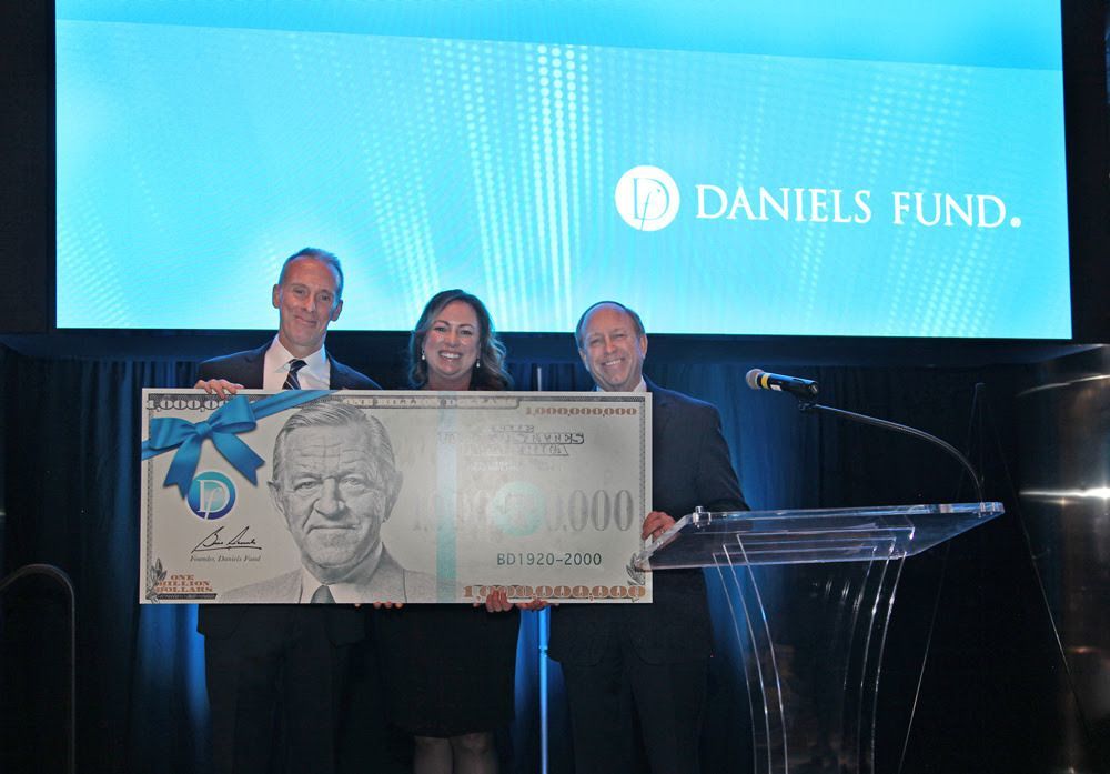 Daniels Fund Board Chair John Suthers (right) and Daniels Fund President & CEO Hanna Skandera (center) present a grant check to Arrupe Jesuit High School President Michael O'Hagan.