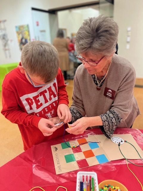 Volunteer helping a student with a craft project