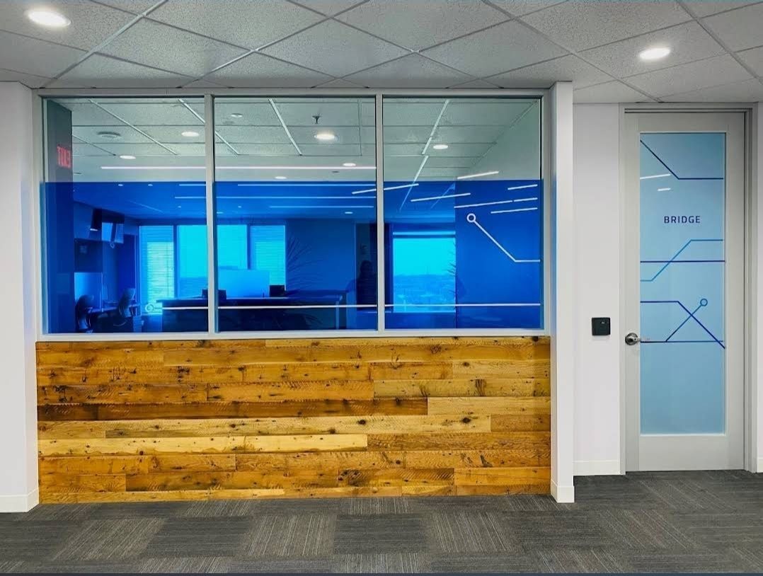 Custom blue window decal with geometric line patterns applied to an interior office window and door, enhancing privacy while maintaining a modern aesthetic.