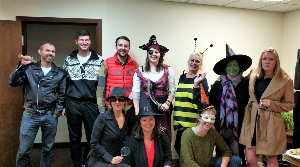 [Image Description: Staff pictured for a Halloween photo, all wearing different attire and smiling.]