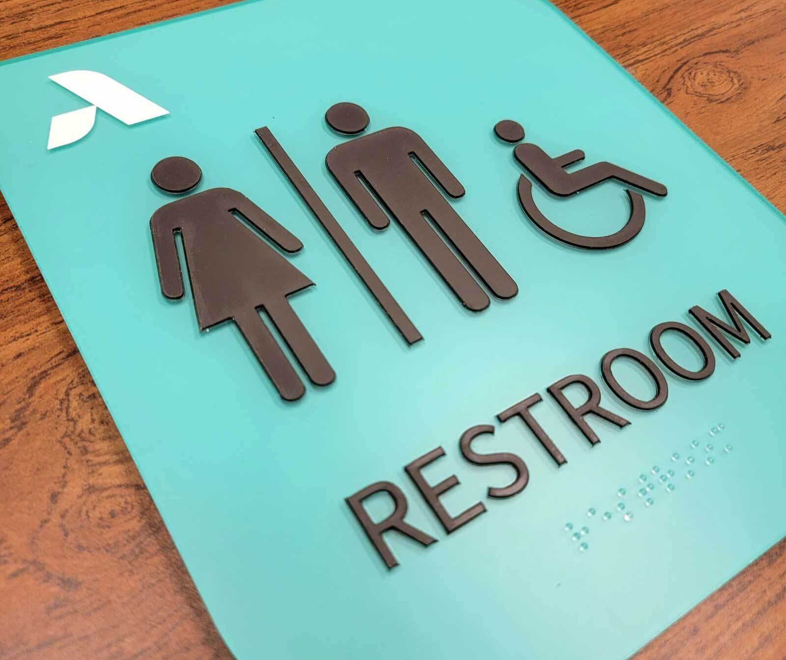 Custom ADA-compliant signs including restroom, wayfinding, and room identification signs for a medical office