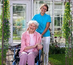 Elderly woman in wheelchair with a nurse.